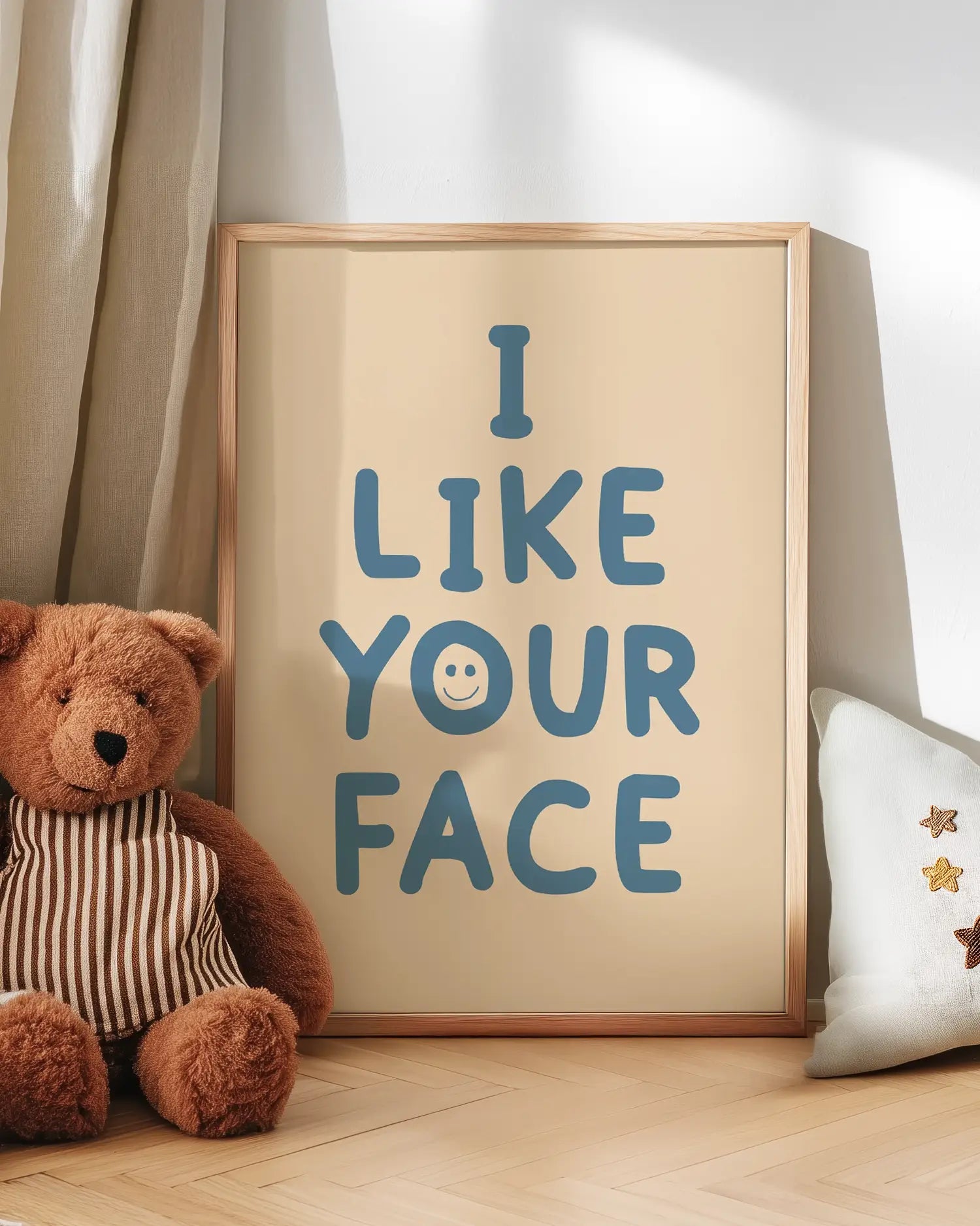 Poster with 'I LIKE YOUR FACE' text next to a teddy bear on a wooden floor.