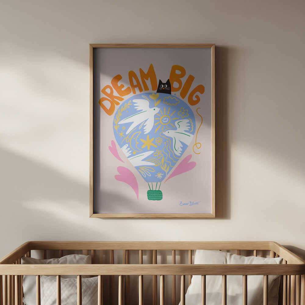 Nursery poster of a hot air ballon and the text 'Dream big' written on it. Hanging on the wall in the kids room above the baby crib.