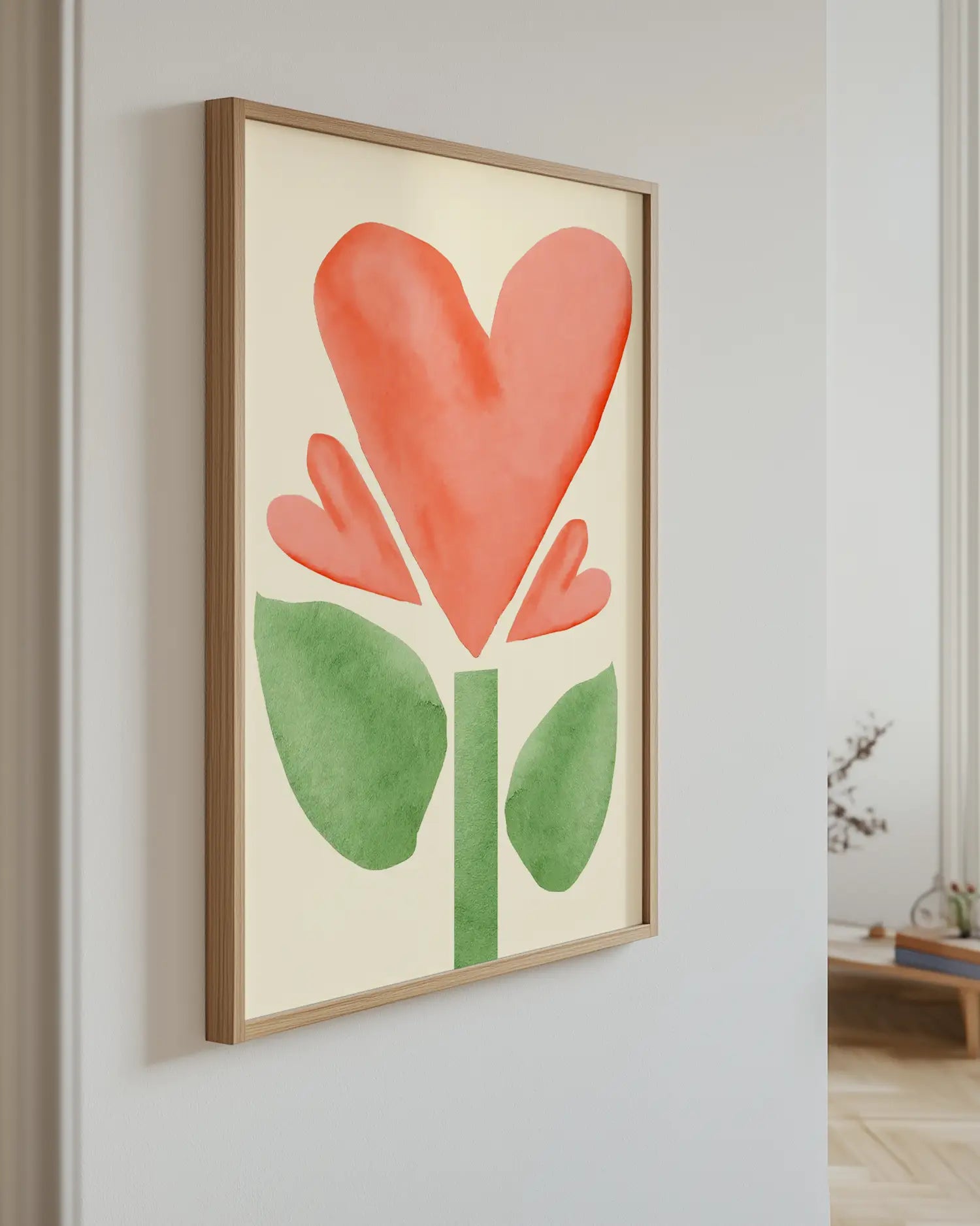 Artwork of a red flower with green leaves on a light wall.