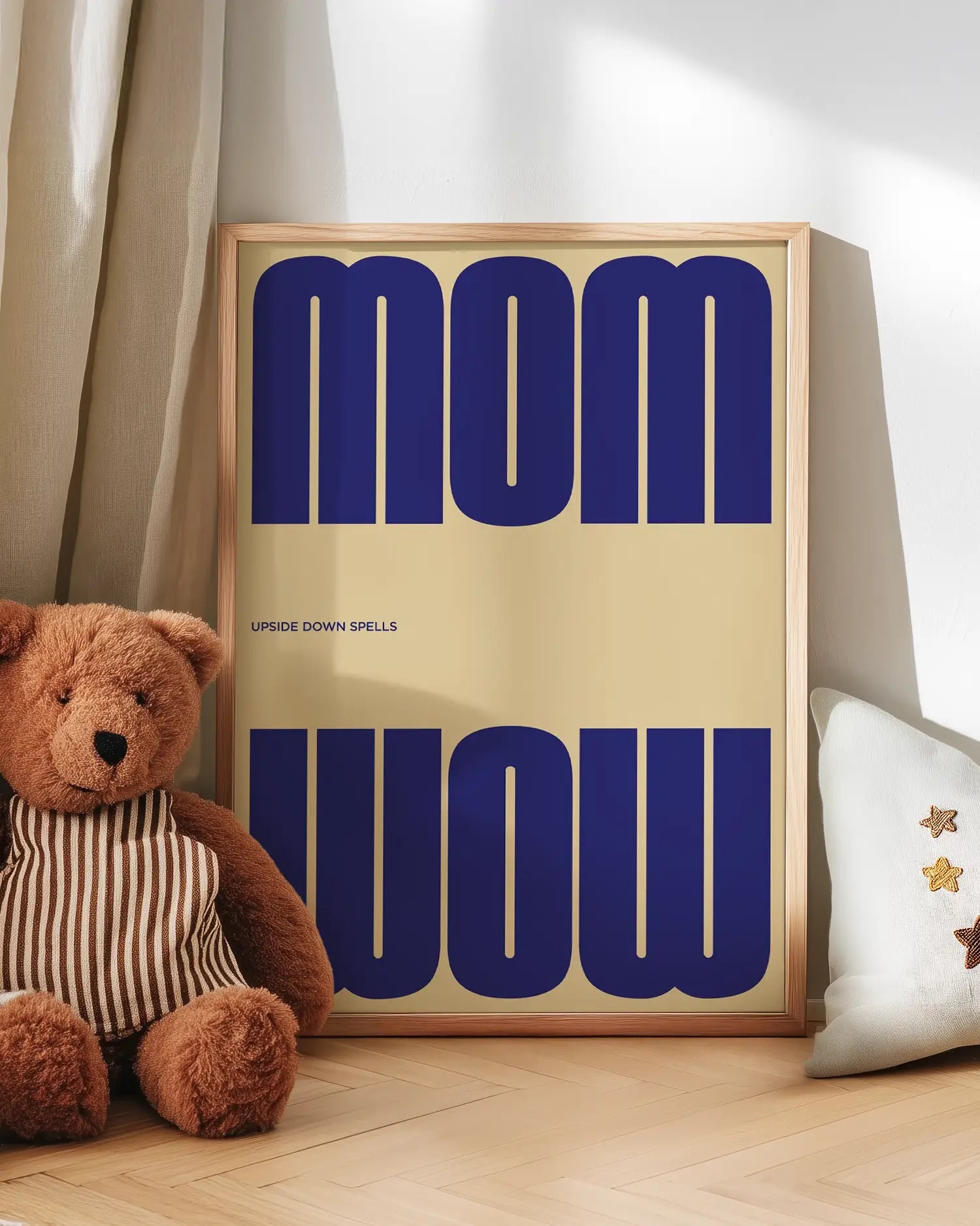 Artwork with 'MOM upside down spells WOW' in blue text next to a teddy bear on a wooden floor.