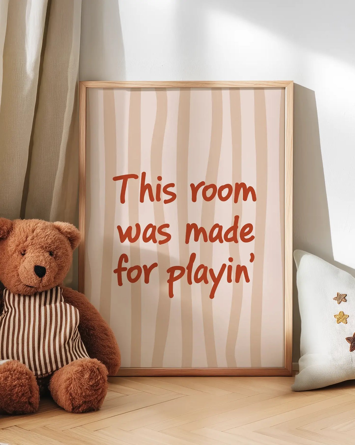 Teddy bear next to a framed poster with text in a room setting – "This rooms was made for playin'"