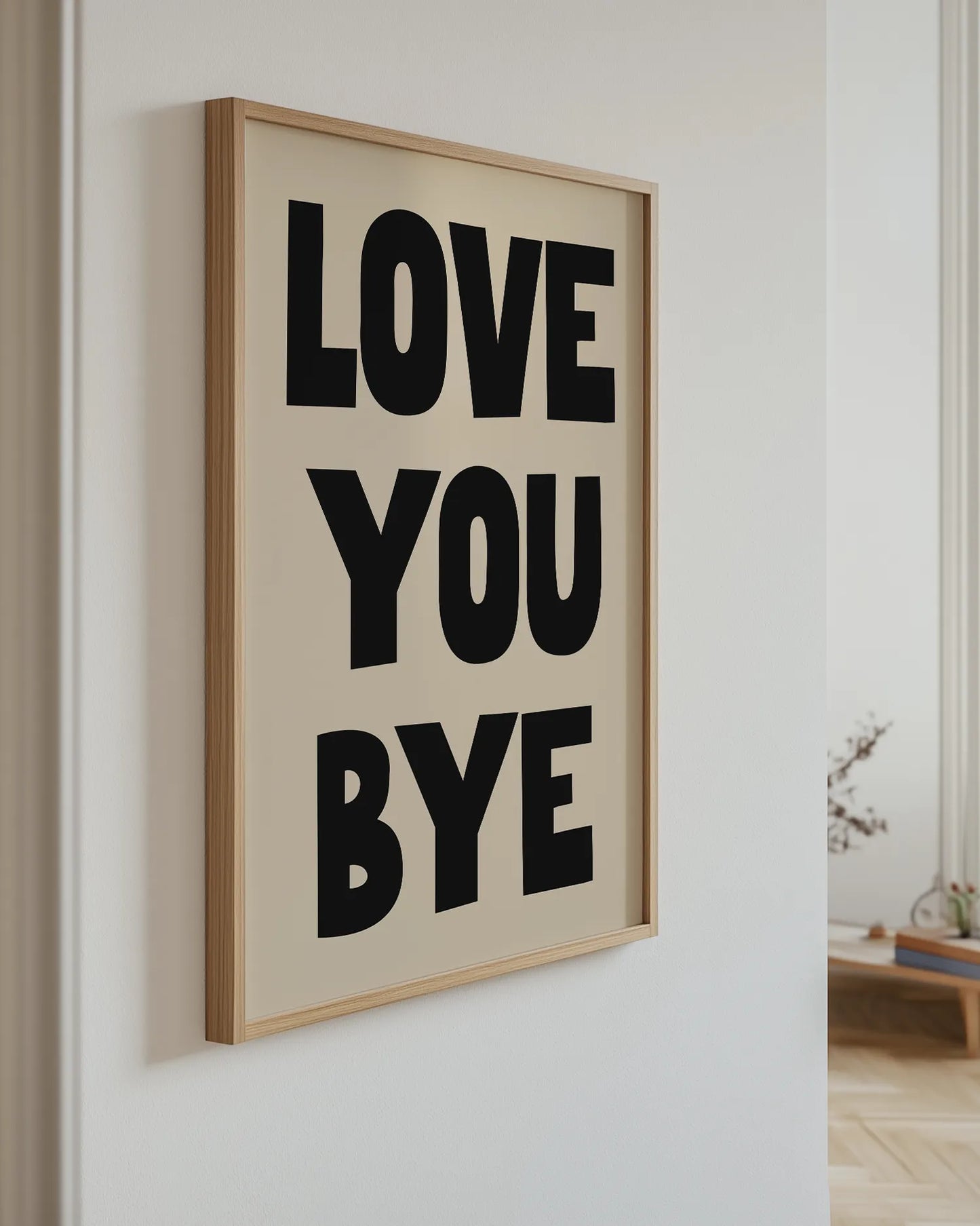 Framed artwork with 'LOVE YOU BYE' text on a wall.