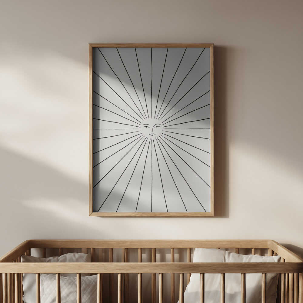 Minimalist sun art print with fine black lines and a calm sun face, framed in light wood and hanging above a baby’s crib. A peaceful and timeless wall art piece that brings light and harmony to a modern nursery.